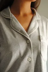 Camisa de manga larga color gris claro con vivos blancos, confeccionada en algodón.