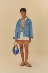 Chaqueta vaquera azul de corte oversize, con cuello clásico, cierre de botones, bolsillos frontales y puños abotonados.