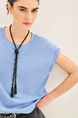 Remera de algodón peruano flamé, color celeste claro, con mangas cortas dobladas y escote redondo. Presenta un largo crop y moldería holgada.