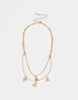 Collar corto multicadena dorado con una cadena de perlas y otra de eslabones, con dijes de cerezas y frutilla con strass.