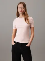 Remera de canalé fino color rosado, con cuello redondo y textura elástica, diseñada para un ajuste perfecto.