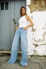Pantalón de jean celeste de tiro medio y corte wide leg, con cinco bolsillos y costuras laterales marcadas.