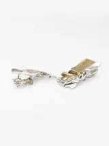 Pendientes grandes de metal con diseño abstracto y textura rugosa, combinando acabados dorado y plateado. Cierre tipo broche.