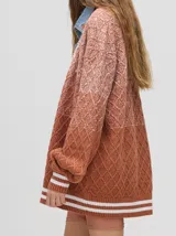 Cardigan tejido de punto con patrón de rombos en degradé de grises y blanco. Tiene corte oversize, mangas largas y cierre frontal con botones.