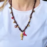 Collar corto hecho en pañuelo marrón con mix de dijes dorados, rojos y blancos.