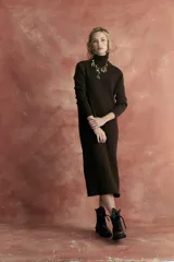 Vestido midi de tejido de punto color marrón chocolate, con cuello alto tipo polera y mangas largas.