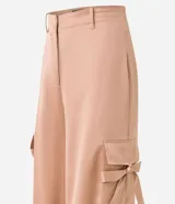 Pantalón wide leg de textura acetinada color café, con bolsillos cargo con solapa en los laterales y tira con moña en los bolsillos y en la barra. Cintura con trabillas y cierre por botón y cremallera.