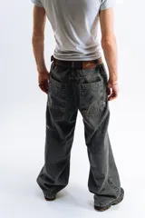 Pantalón de jean azul oscuro con efecto desgastado, corte mega baggy, bolsillos grandes y bordado lateral con el logo de la marca en color blanco.
