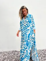 Vestido camisero largo de corte amplio, con estampado abstracto en tonos celeste y crudo.