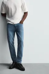Pantalón de jean negro, corte slim fit, con tiro medio, cinco bolsillos, efecto lavado y cierre frontal con cremallera y botón.