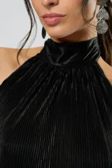 Vestido corto negro plisado con cuello halter y espalda baja. Incluye cinturón de cuero con aros metálicos.