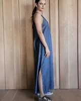 Vestido largo azul melange de corte imperio, con escote en V y breteles finos. Presenta una abertura lateral en la falda.