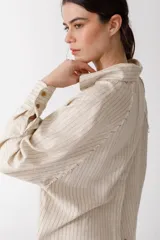 Camisa blanca de lino con botones de madera, corte recto y mangas largas.