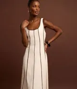 Vestido largo evasé sin mangas, confeccionado en viscolino con 15% de lino. Presenta escote cuadrado en el busto y escote en U en la espalda, con cierre trasero por cremallera. Posee bieses contrastantes.