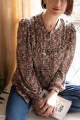 Camisa de gasa estampada con flores, corte clásico, cuello redondo, mangas largas abuchonadas y cierre frontal con botones.