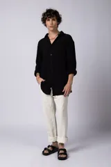 Camisa blanca de lino con cuello clásico, manga larga con puños abotonados y corte holgado. 