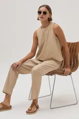 Pantalón chino de lino metalizado color beige, tiro medio-alto y pierna recta. Cuenta con bolsillos laterales y traseros.