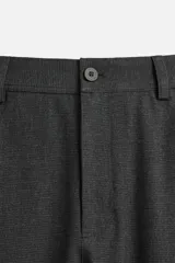 Pantalón slim fit negro confeccionado en tejido con elasticidad en ambas direcciones. Cuenta con bolsillos frontales y traseros de vivo con botón. Cierre frontal con cremallera y botón.