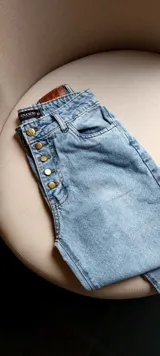 Pantalón de jean celeste de tiro alto, corte recto y etiqueta de cuero marrón en la parte trasera.