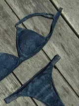 Conjunto de bikini turquesa con corpiño triangular de corte fijo, breteles regulables y almohadillas desmontables, y bombacha vedetina con frunce elástico en los costados.