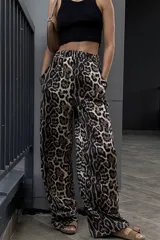 Pantalón largo de tela suave con estampado animal print, cintura elástica y bolsillos frontales.