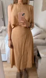 Conjunto de top y falda larga color verde oliva, confeccionado en tusor de algodón. El top es corto y abierto en la espalda, la falda es regulable.