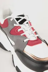 Zapatillas blancas con recortes en diferentes tonos de gris, cordones y plataforma irregular de 5cm.