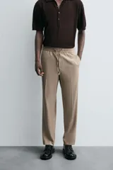 Pantalón color topo de corte recto, con cintura elástica ajustable con cordón, bolsillos laterales y bolsillos de vivo en la espalda.