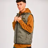 Chaleco acolchado color verde oliva con cierre frontal, bolsillos inferiores tipo welt y logo de Caterpillar en el pecho. Cuenta con ribete elástico en el dobladillo y tecnologías water resistant y recycled insulation.