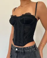 Corset de encaje negro con tirantes finos regulables.