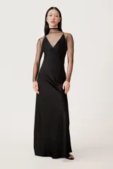 Vestido largo negro de estilo lencero, con escote en pico y tirantes finos cruzados en la espalda.