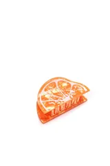 Broche para el pelo con forma de media rodaja de mandarina, color naranja con detalles en blanco.