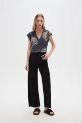 Pantalón de jean color beige, de corte flare y tiro alto, con terminación desflecada.