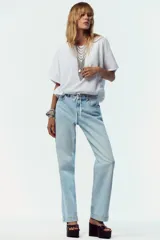 Camiseta blanca de algodón con cuello redondo, mangas cortas y bajo asimétrico ajustable con lazadas.
