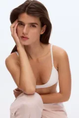 Soutien tipo bralette o top deportivo, color blanco, con tejido acanalado (ribbed) y escote en V pronunciado. Posee breteles finos y ajustables.