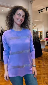Sweater lila de tejido de punto fino con cuello redondo y mangas largas. Presenta líneas horizontales de strass plateado en el frente.