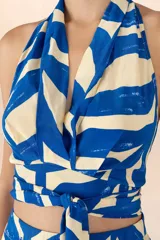 Top halter con estampado de ondas azules y blancas, diseño envolvente y escote en V.
