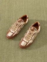 Zapatilla urbana color marrón y dorado, confeccionada en cuero vacuno con recortes en mesh.