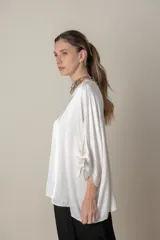 Blusa italiana holgada de color negro con cuello redondo y mangas 3/4 con detalle de lazos.