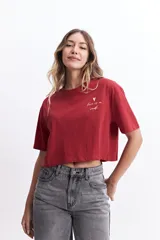 Remera cropped color ladrillo de algodón, con cuello redondo y mangas cortas. Estampa frontal con la frase "Love is a verb" y un corazón.