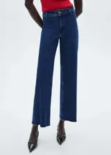 Pantalón de jean azul oscuro, de corte culotte, tiro alto y bajo deshilachado. Con cierre de cremallera y botón, trabillas y bolsillos traseros. Tejido elástico de algodón estilo tejano vaquero.