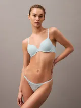 Colaless de encaje elástico transparente en color celeste, con tiras delgadas y ribetes distintivos de Calvin Klein.