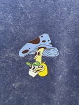 Remera manga corta azul con efecto gastado y estampado de un hongo con sombrero.