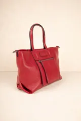 Cartera de símil cuero texturizado color rojo con asas fijas y correa desmontable, con un bolsillo externo de cierre y múltiples compartimientos interiores.