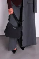 Bolso negro de nylon con textura sutil y manija fruncida.