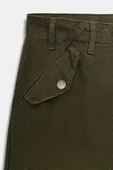 Pantalón cargo de tiro medio color verde militar, confeccionado en algodón. Presenta bolsillos delanteros y bolsillos de plastrón con solapa en las piernas.