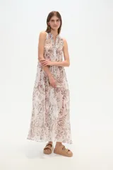 Vestido largo holgado de viscosa, sin mangas, con cuello en V y abotonadura frontal. Presenta un estampado en tonos fucsia, rosado y blanco con motivos étnicos o ikat.