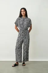 Mono largo negro de corte palazzo con camisa de mangas cortas con botones y lazo en la cintura.