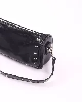 Bandolera marrón de cuero con tachas plateadas y correa de cuero con tachas plateadas. Tiene dos asas desmontables, una corta con tachas para llevarla en la mano o al hombro y una larga para llevarla al hombro o cruzada.