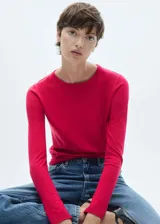 Sweater de punto fino color beige, con cuello redondo y mangas largas.